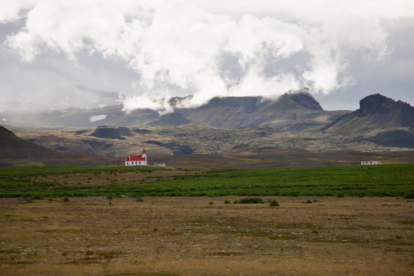 Ingjaldshóll - Kirche vor dem von Wolken verdeckten Snæfellsjökull.