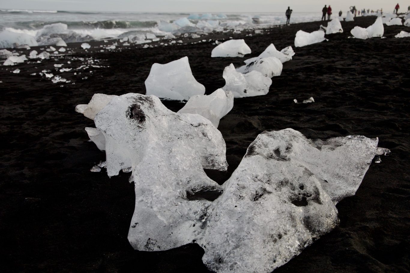 Glitzernde Eisreste auf schwarzen Sand